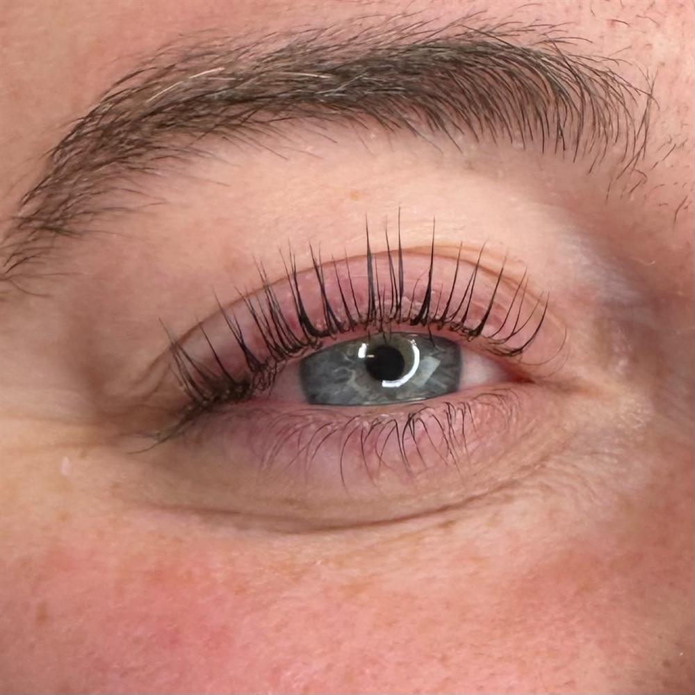 Close-up van een oog met opgekrulde eigen wimpers na een wimperlift